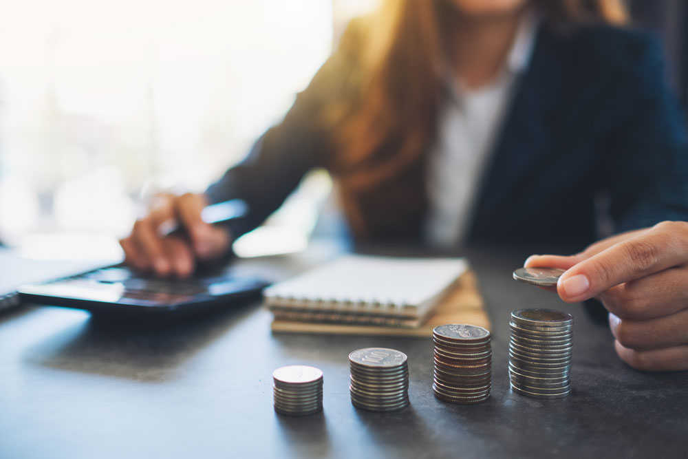Businesswoman saving money at desk